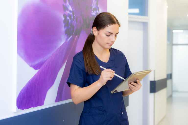 Frau schreibt etwas in ein Tablet